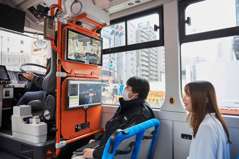 運転席にはドライバー、その背後にオペレーターが同乗。ディスプレイ上部にはバス前方の映像が映し出され、下部には他の車や歩行者が図示される